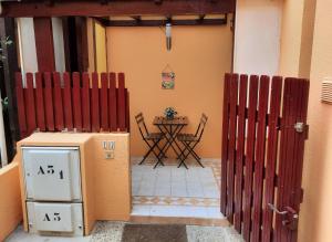 ein Tor zu einem Haus mit einem Tisch im Hintergrund in der Unterkunft Appartement en Résidence avec piscine proche mer in Le Barcarès