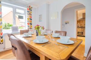 a dining room with a wooden table and chairs at South View in West Runton