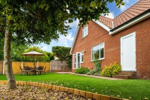 a house with a table and an umbrella in the yard at South View in West Runton