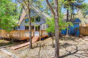 una casa blu con terrazza e alberi di Prescott A-Frame with Deck - 12 Mi to Lynx Lake! a Prescott