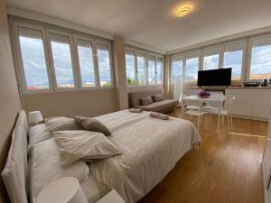een slaapkamer met een bed en een bureau met een televisie bij Attic with great terrace close to the sea in El Campello