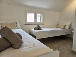 1 dormitorio con 2 camas y ventana en Borgio Verezzi appartamento con parcheggio, en Borgio Verezzi