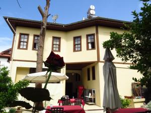 un edificio con una mesa y una sombrilla delante de él en Munchen Pension, en Antalya