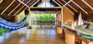 a living room with a hammock in a house at Caiçara Bangalôs Barra Grande Maraú-BA in Barra Grande