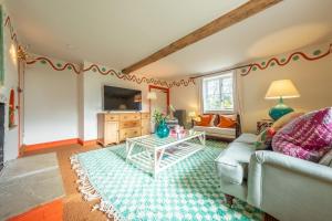a living room with a couch and a table at Keepers Cottage Wolterton in Aylsham
