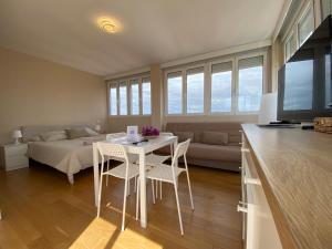 een woonkamer met een tafel en stoelen en een bed bij Attic with great terrace close to the sea in El Campello