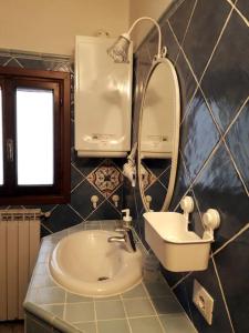 bagno con lavandino e specchio di Appartamento nel centro storico di Fiumalbo a Fiumalbo