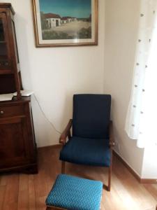 una sedia blu e uno sgabello in una stanza di Appartamento nel centro storico di Fiumalbo a Fiumalbo
