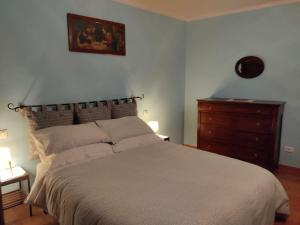 una camera con un grande letto e un comò di Appartamento nel centro storico di Fiumalbo a Fiumalbo