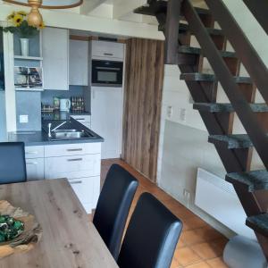 een keuken met een tafel en stoelen en een wenteltrap bij Le Vieux Sart 2 in Stavelot