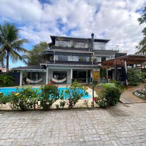 a house with a swimming pool in front of it at Pousada Casa da Praia in São Francisco do Sul