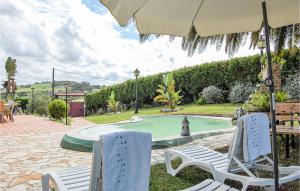 two chairs and an umbrella next to a swimming pool at 3 Bedroom Awesome Home In Antromero in Candás +22 photos