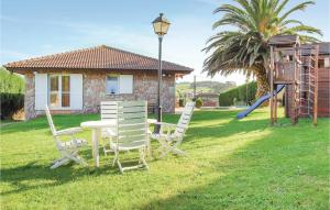 a table and chairs in a yard with a playground at 3 Bedroom Awesome Home In Antromero in Candás