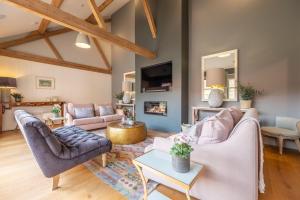 a living room with two couches and a tv at Horse Yard Barn in Warham