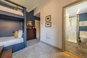 a bedroom with a bed and a bathroom at Horse Yard Barn in Warham