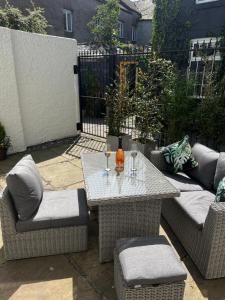 a table and chairs with wine glasses on a patio at Ulverston stunning 1 bedroom apartment in Ulverston