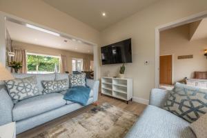 a living room with a couch and a tv at Hedgerows 8 in Burnham Market