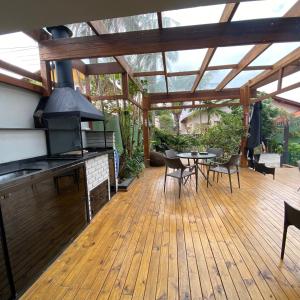 an outdoor deck with a grill and a table and chairs at Pousada Casa da Praia in São Francisco do Sul