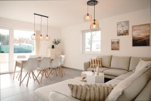 a living room with a couch and a table and chairs at SKAN-PARK Ferienhäuser & Tiny Houses am Bärwalder See in Jahmen Ausbau
