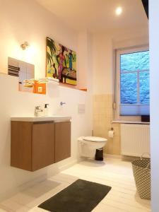 ein Bad mit einem Waschbecken, einem WC und einem Fenster in der Unterkunft Ferienwohnung am Schloss Colditz in Colditz