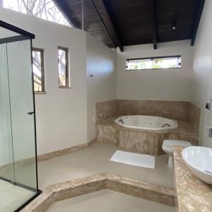 a bathroom with a tub and a sink at Pousada Casa da Praia in São Francisco do Sul