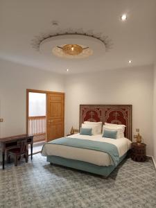 una camera con un grande letto e un tavolo di Riad Mellah a Essaouira