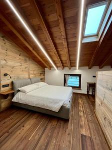 a bedroom with a bed in a room with wooden ceilings at La Louye su La Goumba in Pontboset