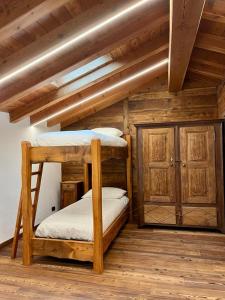 La Louye su La Goumba في Pontboset: سريرين بطابقين في غرفة ذات سقوف خشبية
