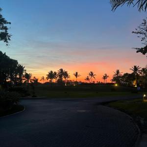 a sunset with palm trees and a road at Elegante y espacioso Apartamento en Playa Blanca in Río Hato