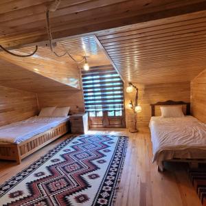 1 Schlafzimmer mit 2 Betten und einem Teppich in der Unterkunft Selin Yaşam Evi in Artvin