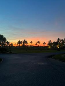 a sunset with palm trees and a road at Elegante y espacioso Apartamento en Playa Blanca in Río Hato
