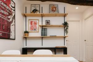 a room with a table and chairs and shelves at Apartamento en corazón histórico in Lugo