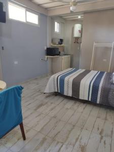 een slaapkamer met een bed en een houten vloer bij Alojamiento temporario in Formosa