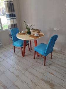 een tafel en twee blauwe stoelen in een kamer bij Alojamiento temporario in Formosa