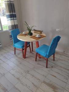 a table and two blue chairs in a room at Alojamiento temporario in Formosa