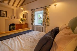 a bedroom with a bed and a window at The Stables in North Walsham