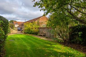a house with a yard with a green lawn at The Stables in North Walsham