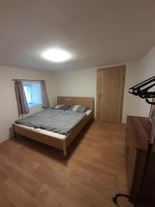 - une chambre avec un lit et du parquet dans l'établissement Apartmány Míra, à Nová Pec