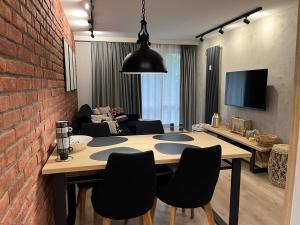 uma sala de estar com uma parede de tijolos e uma mesa e cadeiras em Apartament Śródmieście em Augustów
