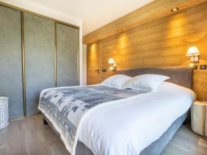 a bedroom with a large bed with a wooden wall at Appartement Tignes, 3 pièces, 5 personnes - FR-1-480-84 in Tignes