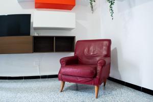 a red leather chair sitting in a room at Appartamento Azzurra in Melendugno