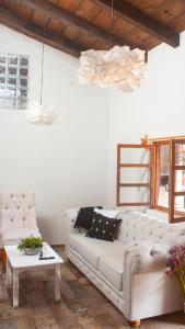 a living room with a white couch and a table at Noma Bed & Breakfast in San Cristóbal de Las Casas