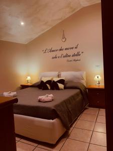 un dormitorio con una cama con una cita en la pared en La Candida Rosa L T Anagni, en Anagni