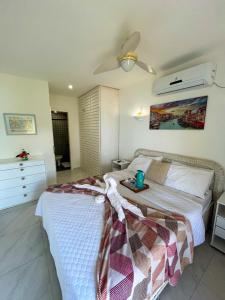 ein Schlafzimmer mit einem Bett und einem Tisch darauf in der Unterkunft Apartamento no Porto Real Resort com vista para praia para 6 adultos e 4 adolescentes in Mangaratiba