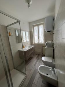 uma casa de banho com um chuveiro, um WC e um lavatório. em Appartamento Eugenio em Colico