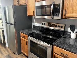 a kitchen with a stove and a stainless steel refrigerator at Luxury Modern Condo by the Lake - Succulent Way in Branson