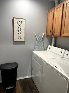 a laundry room with a washing machine and a picture on the wall at Luxury Modern Condo by the Lake - Succulent Way in Branson