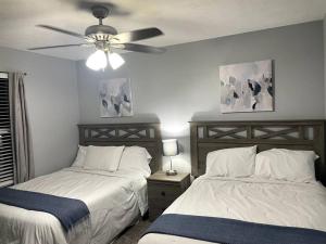 a bedroom with two beds and a ceiling fan at Luxury Modern Condo by the Lake - Succulent Way in Branson