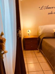 1 dormitorio con 1 cama y 1 mesa con lámpara en La Candida Rosa L T Anagni, en Anagni