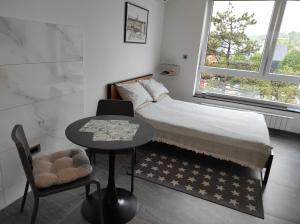 Dormitorio pequeño con cama, mesa y silla en Park Lake - Germa en Tuzla